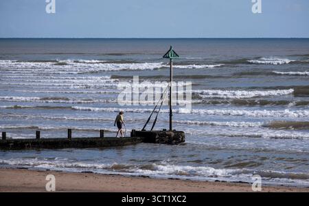 Das Sonnenlicht reflektiert den Ozean und schafft Silhouetten an der Küste von Sidmouth, Devon an der Südküste Englands. Stockfoto