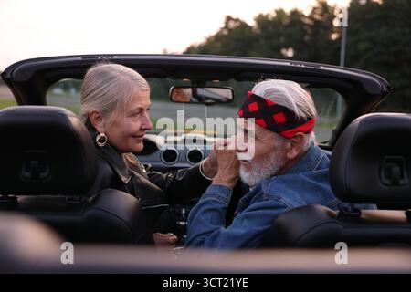 Stilvolles Seniorenpaar in modernem Cabriolet im Freien Stockfoto