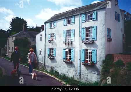 Vereinigtes Königreich. England. Dorset. Lyme Regis. Dreistöckiges Haus. Ein Paar Spazierhund entlang des Lynch River Lim Gehwegs. Stockfoto
