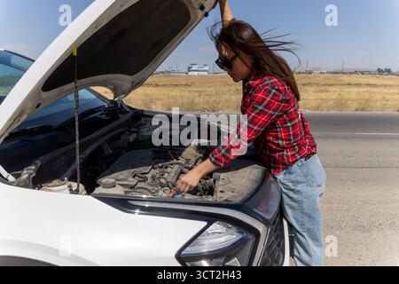 Frau, die den Motor im Freien inspiziert Stockfoto