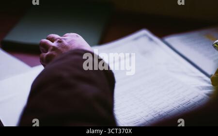 Blättern durch ein Blatt Papier. Hände eines Mannes über ein Blatt Papier Stockfoto