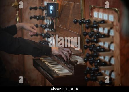 Ein Pianist, der auf einer antiken Kirchenorgel spielt, Detail der Hände und Tastatur Stockfoto