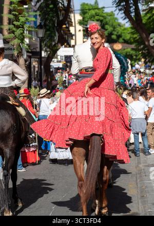 Fuengirola, Malaga, Spanien. 28. September 2025. Paare auf dem Pferd tragen traditionelle andalusische Kleidung vor dekorierten Wagen für die Pilgerfahrt Stockfoto