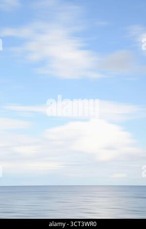 Künstlerisch verschwommener Hintergrund von Meer, Himmel, weiße Wolken in blau-grauen weißen Farben mit Kopierraum Stockfoto