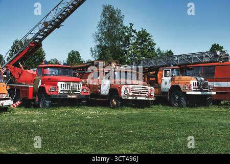 Alte Feuerwehrfahrzeuge in verlassenem Zustand unter klarem blauem Himmel Stockfoto