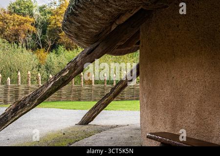 Äußere des Viking Longhouse mit Strohdach, Holzstützen und Flechtzaun im Irish National Heritage Park, Wexford Stockfoto