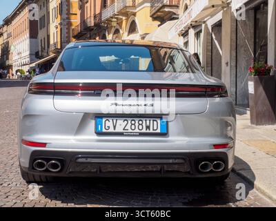 Cremona, Italien 29. Juli 2025 Rückansicht des silbernen Porsche Panamera 4S mit sichtbarem Logo, geparkt auf einer Kopfsteinpflasterstraße in städtischer Umgebung, Showcasin Stockfoto