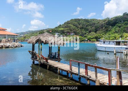 Isla de Roatan, Honduras - 16. April 2024: Ein Pavillon unter dem Stroh auf der Pier auf Roatan Island, Honduras. Stockfoto