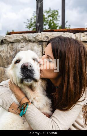 Frau küsst Golden Retriever im Freien. Lifestyle. Tiere. Stockfoto