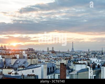 Die Skyline von Paris bei Sonnenuntergang mit dem Eiffelturm und Invalidendom, goldenes Licht über den Haussmann-Dächern. Stockfoto