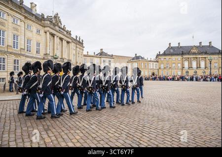 Soldaten ziehen mit Zuschauern vor historischen Gebäuden auf einem Platz, Wechsel der Garde der königlichen Garde, Schloss Amalienborg, Kopenhagen Stockfoto