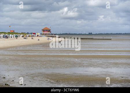 Strandlandschaft mit Gezeiten, Menschen und einem Küstengebäude, Hooksiel, Friesland, Wangerland, Niedersachsen, Deutschland Stockfoto