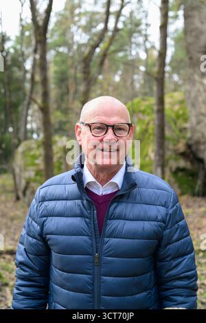 Porträt eines lächelnden skandinavischen Seniors mitten im Wald Stockfoto