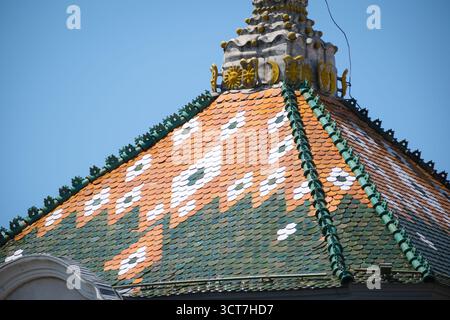 Buntes Ziegeldach des alten Rathauses in Targu Mures, Rumänien, mit geometrischen Mustern und verzierten Details Stockfoto