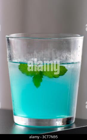 Erfrischendes blaues Eisgetränk mit Minzblättern Stockfoto