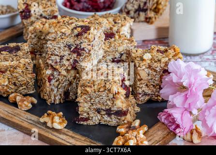 Hausgemachte Frühstücksbars aus Haferflocken, Nüssen, getrockneten Preiselbeeren und Honig Stockfoto
