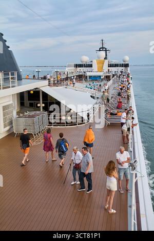 Venedig. Italien - 03. Oktober 2025: Passagiere und Touristen entspannen sich auf Liegestühlen auf dem Oberdeck eines großen Kreuzfahrtschiffs und genießen die Sonne und das Meer VI Stockfoto