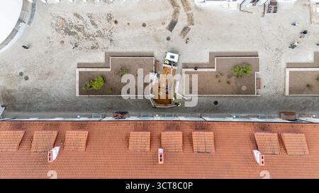 Luftaufnahme einer Baustelle mit einem kleinen Bagger, der auf der Landschaftsgestaltung arbeitet. Stockfoto