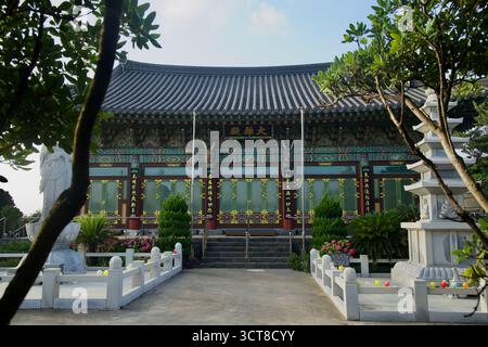 Der vordere Innenhof des Yongmunsa Tempels umrahmt die Haupthalle von Daeungjeon mit einer Pagode aus Stein, Laternen, Sträuchern und geschnitzten Details unter dem Schwung Stockfoto