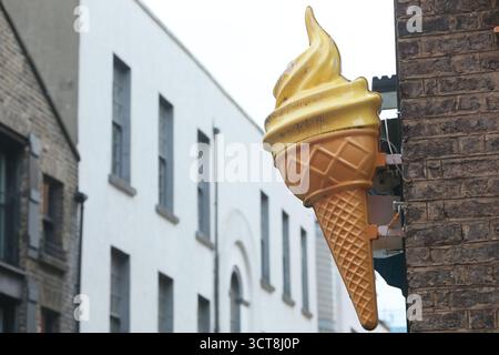 Dublin, Irland - 14. August 2025 - Ein großes gelbes Plastikschild mit Schlagsahne an einer Wand in der Temple Bar im Stadtzentrum von Dublin Stockfoto