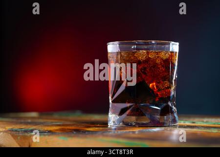 Whiskey und Cola in einem Glas mit Eis auf dem Tisch Stockfoto