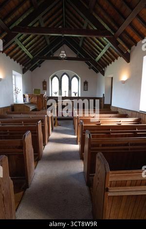 Das Innere der traditionellen Kirche mit Holzbänken und freiliegender Balkendecke auf der Isle of man Stockfoto