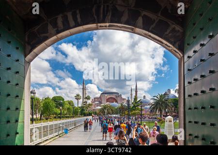 Touristen fahren an einem hellen Tag mit erstaunlichen weißen Wolken zur Hagia Sophia, dem beeindruckendsten architektonischen Meisterwerk des Byzantinischen Reiches Stockfoto