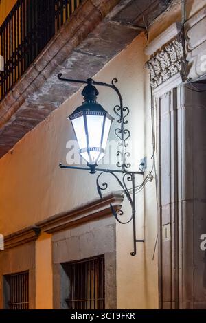 Eine Straßenlaterne mit weißem Licht hängt an einem Gebäude. Die Anzeige leuchtet. Historisches Zentrum von Queretaro, Kolonialarchitektur, Dekorationen für die Stockfoto