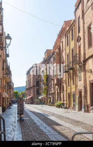 Bosa, Eine bezaubernde italienische Straßenszene mit Kopfsteinpflasterpflasterpfaden und farbenfrohen historischen Gebäuden unter klarem Himmel. Diese friedliche Stadt Stockfoto
