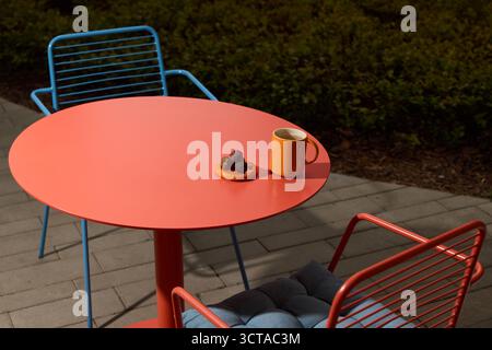 Ein farbenfroher und einladender Outdoor Cafe Tisch mit Kaffee, Snacks und Leckereien Stockfoto
