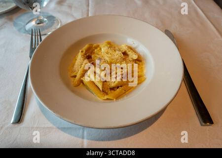 Genießen Sie einen Klassiker Italiens: Köstliche Penne Carbonara, perfekt umhüllt in einer cremigen Sauce mit knusprigem Guanciale und geriebenem Käse, serviert o Stockfoto