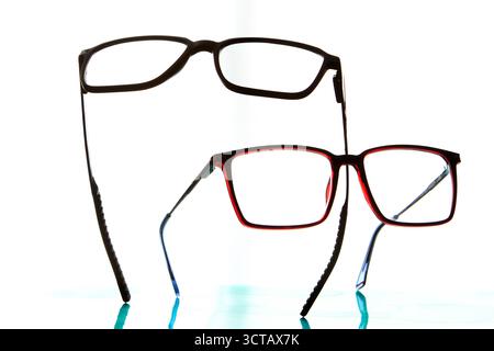 Studio-Foto von zwei Brillen mit verschiedenen Rahmenfarben isoliert auf weißem Hintergrund, die optisches Design, Sehkorrektur und modernes Auge symbolisieren Stockfoto