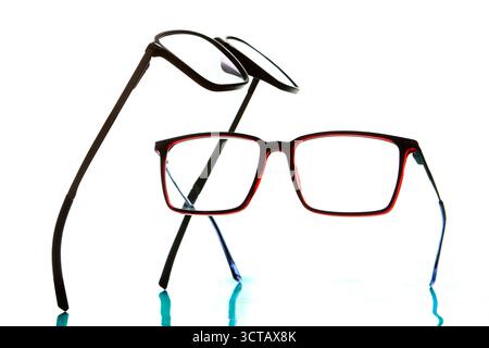 Studiokomposition aus roten und schwarzen Brillen isoliert auf weißem Hintergrund, die optische Mode, Gesundheitswesen und modernes Design darstellen. Stockfoto