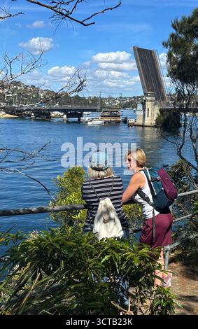 Zwei Frauen beobachten Boote, die durch eine erhöhte Brücke, die Spit, Nord-Sydney, NSW, Australien fahren. Kein MR oder PR Stockfoto