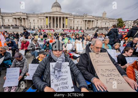London, Großbritannien. Oktober 2025. Demonstranten, die illegale Plakate zur Unterstützung der verbotenen Gruppe Palestine Action halten und auf Verhaftung warten. Fast 500 Demonstranten wurden auf dem Trafalgar Square verhaftet, weil sie Schilder zur Unterstützung der verbotenen Gruppe Palestine Action aufhielten. Die Massenaktion sollte die Fähigkeit der Polizei in Frage stellen, das Terrorismusgesetz durchzusetzen, das die Unterstützung verbotener Organisationen verbietet. Quelle: SOPA Images Limited/Alamy Live News Stockfoto