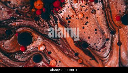 Ölmarmor. Tintenmischung. Defokussierte orange rot lila Farbe Splatter Glitter Runde Wasserblasen dunkelschwarze Emulsion verschütten auf abstraktem Hintergrund. Stockfoto