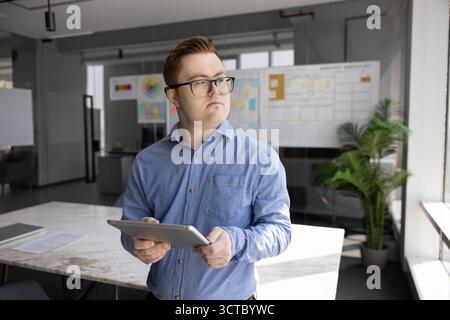 Nachdenklicher männlicher Angestellter bei Brille mit Down-Syndrom Stockfoto