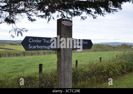 Ein Wegweiser auf dem Cinder Track, ein Rad- und Gehweg auf der stillgelegten Eisenbahnstrecke zwischen Whitby und Scarborough in North Yorkshire Stockfoto