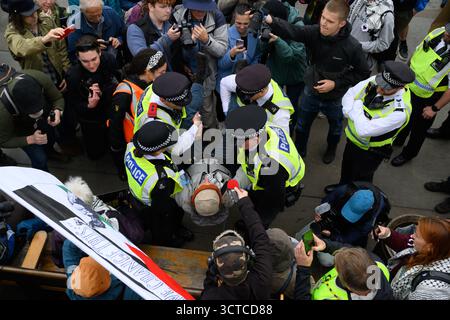 Die Polizei führt einen verhafteten Demonstranten aus dem Trafalgar Square im Zentrum Londons während der Demonstration „Lift the Ban“ zur Unterstützung der verbotenen Gruppe Stockfoto