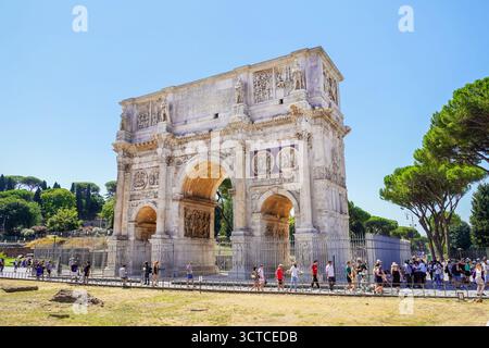 Touristen laufen auf einem Gehweg vor dem Konstantinsbogen Stockfoto