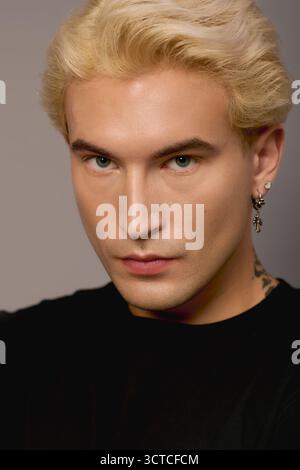 Ein hübscher Teenager mit blondem Haar und auffälligen Details zeigt Mode und Selbstvertrauen. Stockfoto