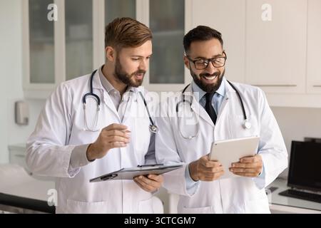 Zwei Ärzte, die weiße Labormäntel tragen, arbeiten im Krankenhaus zusammen Stockfoto