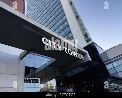 Manchester, Großbritannien - 25. September 2025: Moderner Stadtturm mit großem beleuchtetem Schild, Glaswänden und modernen architektonischen Linien. Stockfoto