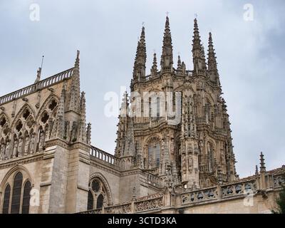 Burgos Cathedral Turmdetail am bewölkten Tag - komplizierte Details des verzierten zentralen Turms und der gotischen Gipfel der Burgos Cathedral unter grauem Himmel Stockfoto