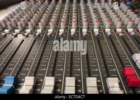 Nahaufnahme der Fader und Regler auf einem Mischpult in einem hohen Winkel – detaillierte Ansicht der professionellen Audiogeräte, die zum Mixen, Aufnehmen und Live-Spielen verwendet werden Stockfoto