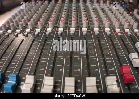 Nahaufnahme der Fader und Regler auf einem Mischpult in einem hohen Winkel – detaillierte Ansicht der professionellen Audiogeräte, die zum Mixen, Aufnehmen und Live-Spielen verwendet werden Stockfoto