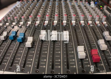 Nahaufnahme der Fader und Regler auf einem Mischpult in einem hohen Winkel – detaillierte Ansicht der professionellen Audiogeräte, die zum Mixen, Aufnehmen und Live-Spielen verwendet werden Stockfoto