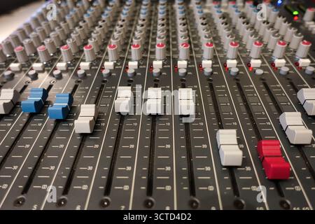 Nahaufnahme der Fader und Regler auf einem Mischpult in einem hohen Winkel – detaillierte Ansicht der professionellen Audiogeräte, die zum Mixen, Aufnehmen und Live-Spielen verwendet werden Stockfoto