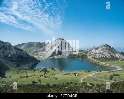 Natürlicher Alpensee in Picos de Europa Spanien - atemberaubende Berglandschaft mit tiefblauem See und gewundenen Straßen, perfekt für Reisen und Naturkonzept Stockfoto