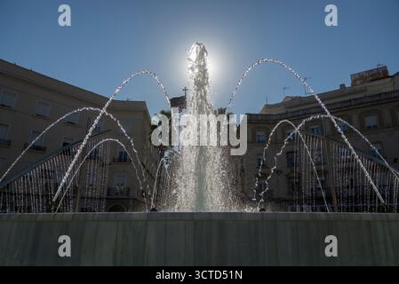 Beleuchteter Wasserbrunnen auf der Plaza de las Monjas in Huelva, der Licht reflektiert, während es durch das Wasser fließt. Stockfoto